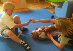 instruktorka podaje karmę chłopcu dla psa