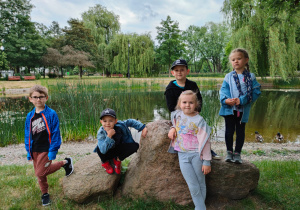przedszkolaki pozują do zdjęcia w parku miejskim w Zduńskiej Woli przy dużym kamieniu