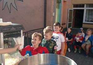 przedszkolaki otrzymują prażoną kukurydzę do degustacji