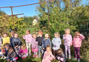 przedszkolaki stoją przed jabłonkami