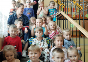 przedszkolaki z grupy III siedzą na schodach przedszkolnych w piżamkach