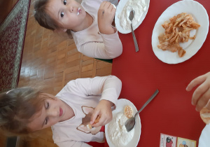 dziewczynki jedzą podwieczorek - serek z chipsami jabłkowymi
