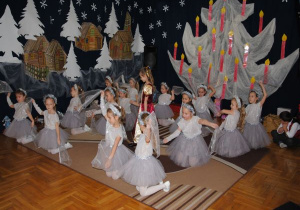 dziewczynki wykonują taniec śnieżynek z chustkami klęcząc w rzędach