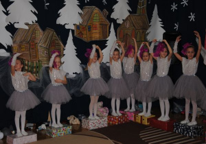 dziewczynki - lalki stoją na kolorowych paczkach w pozycji baletowej z jedną ręką w górze