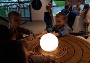 przedszkolaki obserwują model układu słonecznego