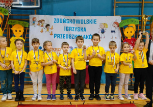 drużyna dzieci z zawieszonymi medalami na szyi i pucharem
