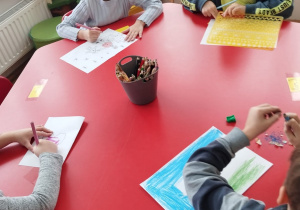 przedszkolaki rysują obrazki siedząc przy stoliku