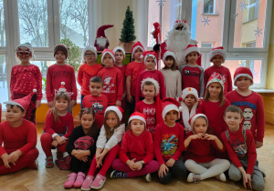 dzieci w czerwonych strojach z grupy VIII z Mikołajem