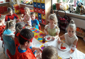 dzieci jedzą galaretkę przy stolikach