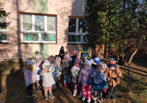 grupa przedszkolaków ze smakołykami dla ptaków przed przedszkolem