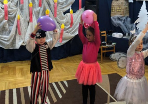 dzieci tańczą z balonami i trzymają je nad głową