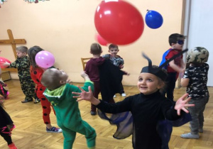 dzieci bawią się kolorowymi balonami podrzucając je do góry