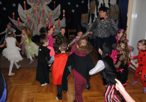 dzieci tańczą w kole z nauczycielką