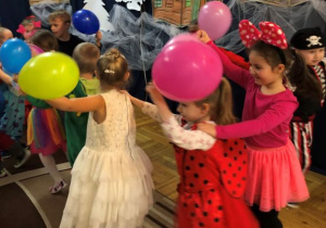 dzieci z balonami tańczą w "wężu"