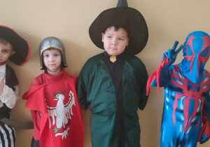 chłopcy w strojach karnawałowych: pirat, rycerz, czarodziej i super bohater