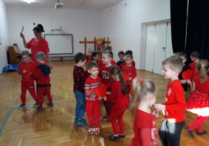 zabawy z Panią Nutką - dzieci tańczą w parach trzymając duże serce