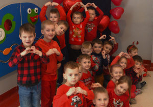 zdjęcie dzieci z grupy VII z dłońmi złożonymi w kształt serca