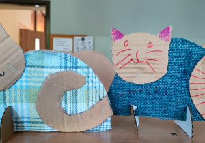 praca plastyczna - koty z tektury w kolorowych ubraniach