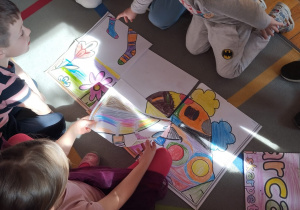 przedszkolaki ukladają puzzle, które wcześniej pokolorowały