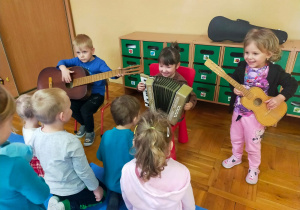 przedszkolaki grają na gitarach i akordeonie