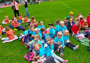 przedszkolaki piknikują na murawie stadionu