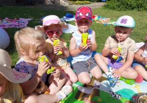 dzieci piknikują w ogrodzie przedszkolnym