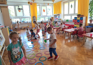 zabawy dzieci w sali na podłodze i przy stolikach