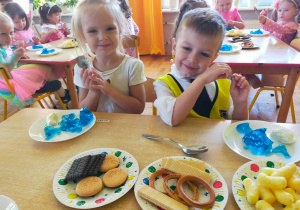 słodki poczęstunek zniebieską galaretką, bananem i ciasteczkami