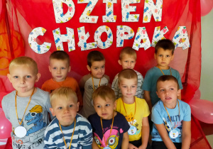 chłopcy z gr V pozują do zdjęcia w ramce z napisem Dzień Chłopaka