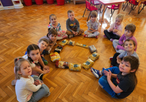 przedszkolaki siedzą wokół różnego rodzaju makaronów