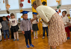 chłopiec podczas pasowania na przedszkolaka przez panią dyrektor