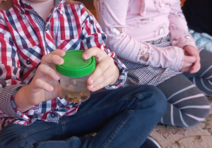 dzieci pokazują preparaty w pojemnikach