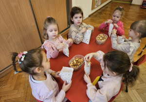 dziewczynki pakują suszone jabłka do papierowych torebek na upominek dla babci i dziadka