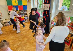 mamy tańczą w parach z dzieckiem trzymając się za ręce