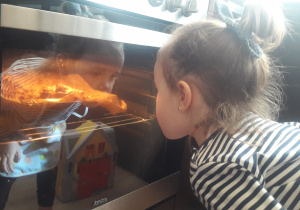 dziewczynka zagląda do piekarnika