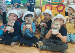 chłopcy w białych kapeluszach pokazują swoje upominki