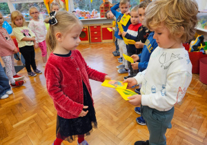 dziewczynka wręcza swoją laurkę chłopcu