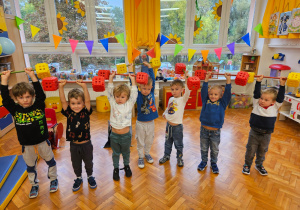 chłopcy podnoszą sztangi wykonane z klocków