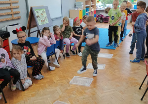 zabawa skoczna - chłopcy przeskakują rozłożone pokrywki od pojemników