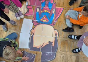 dzieci układają puzzle - super bohatera