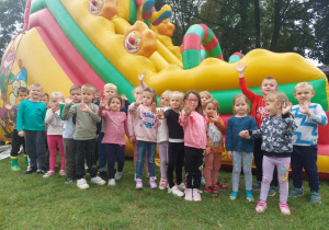 dzieci stoją przed dmuchaną zjeżdżalnią
