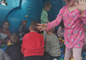 przedszkolaki w dmuchańcu z kolorowymi piłeczkami
