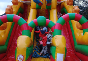 dzieci wchodzą na dmuchańca ze zjeżdżalnią