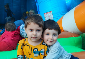 chłopcy przed dmuchańcem z kuleczkami