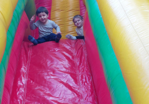 dzieci zjeżdżają na dmuchanej zjeżdżalni