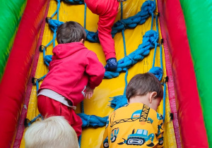 dzieci wchodzą po drabince na zjeżdżalnię