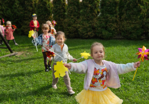 przedszkolaki idą w korowodzie i machają wiatraczkami i liśćmi