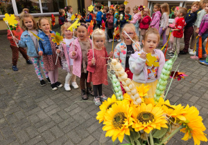 dzieci przygotowują się do korowodu z jesiennymi akcesoriami