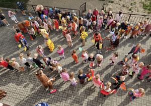 przedszkolaki na tarasie ustawiają się do korowodu z jesiennymi akcesoriami