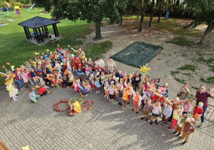 przedszkolaki na tarasie pozują do zdjęcia grupowego z jesiennymi akcesoriami